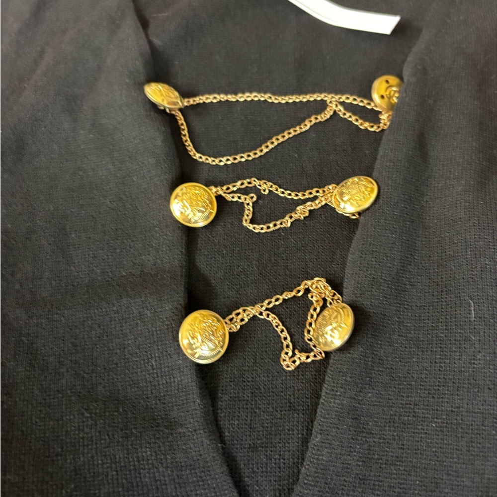 ASOS black dress with gold chains draping the chest area.